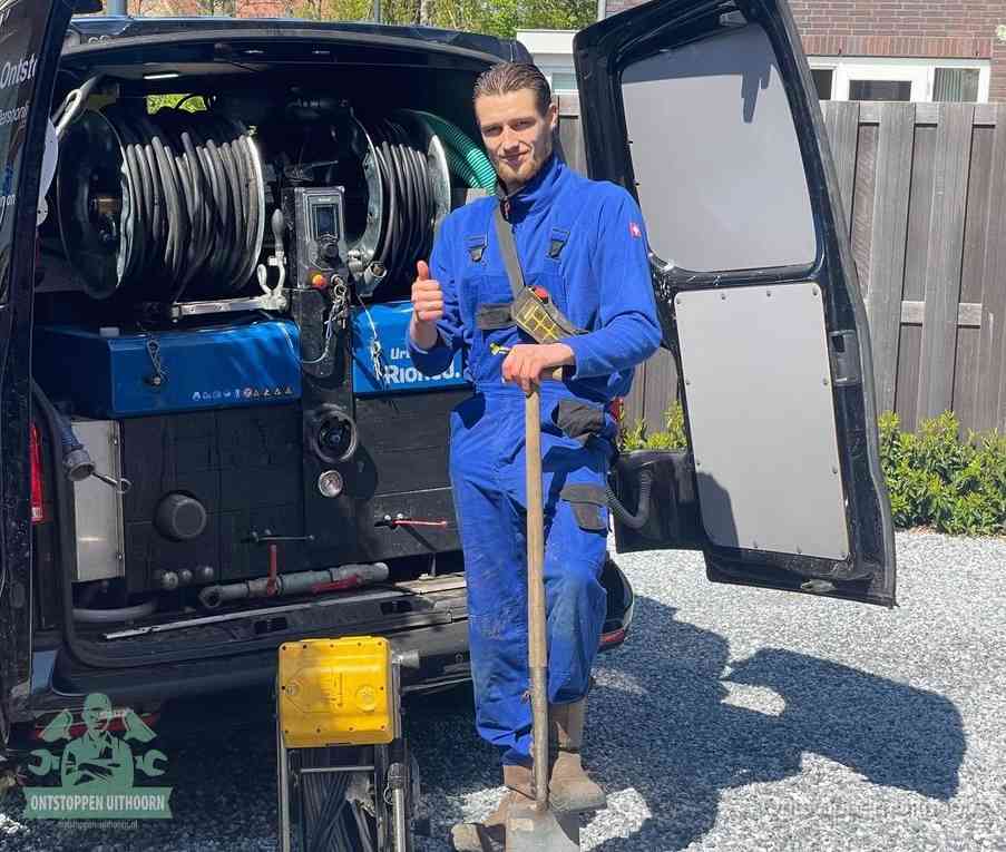 Een tevreden monteur met opgestoken duim naast de bestelbus, slim ingrijpen bespaart kosten bij een verstopte afvoer in Uithoorn