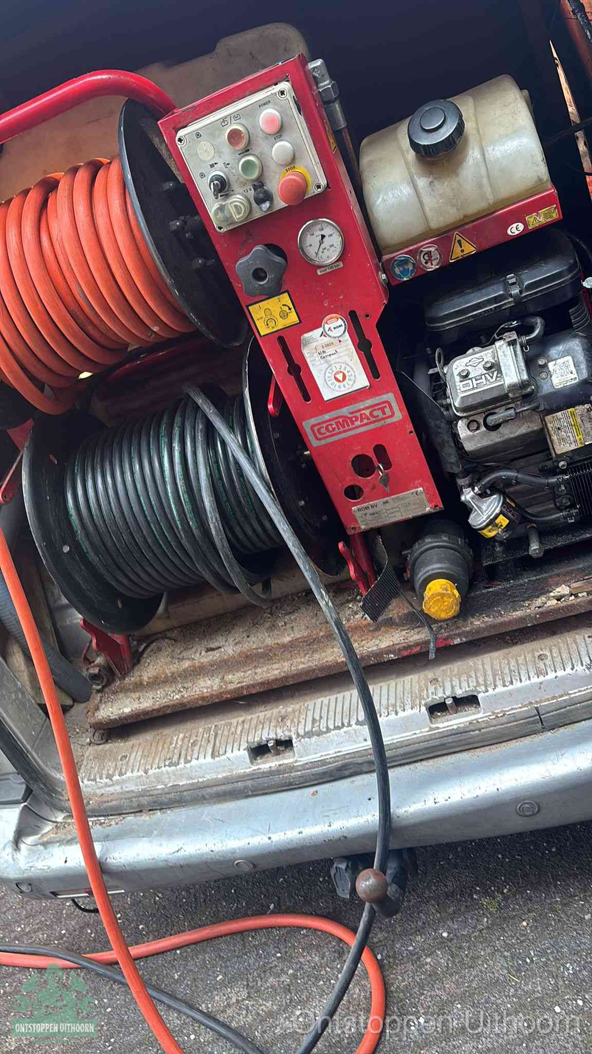 Een rood hogedruk-rioolreinigingstoestel in de laadbak van de bedrijfsbus, apparatuur voor een hardnekkige afvoerverstopping in Uithoorn