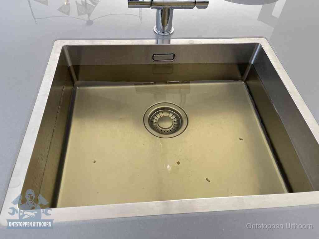 Stilstaand water in een rvs spoelbak dat niet wegloopt, een duidelijk signaal van een gootsteenverstopping in Uithoorn