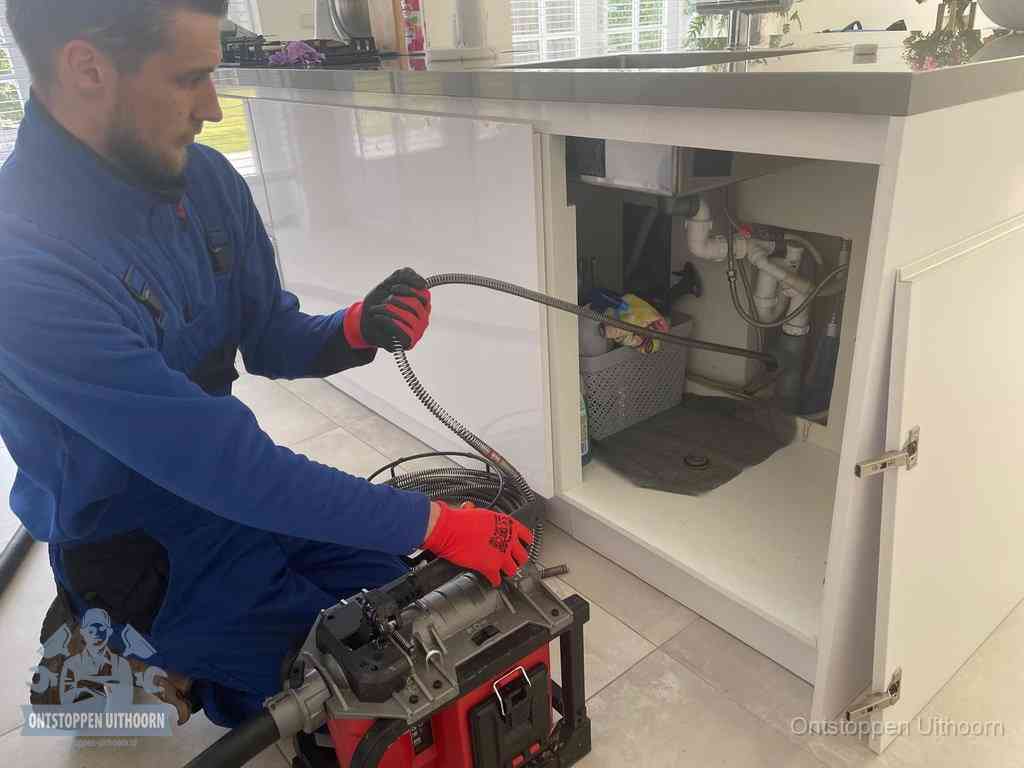 Een monteur reinigt de keukenafvoer grondig met een veermachine om terugkerende gootsteenverstoppingen te voorkomen in Uithoorn