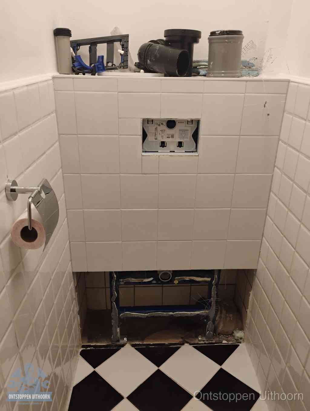 Een toiletruimte waar het hangtoilet en de inbouwreservoir-onderdelen zijn vrijgelegd voor onderhoud, periodiek nazicht voorkomt een wc-verstopping in Uithoorn